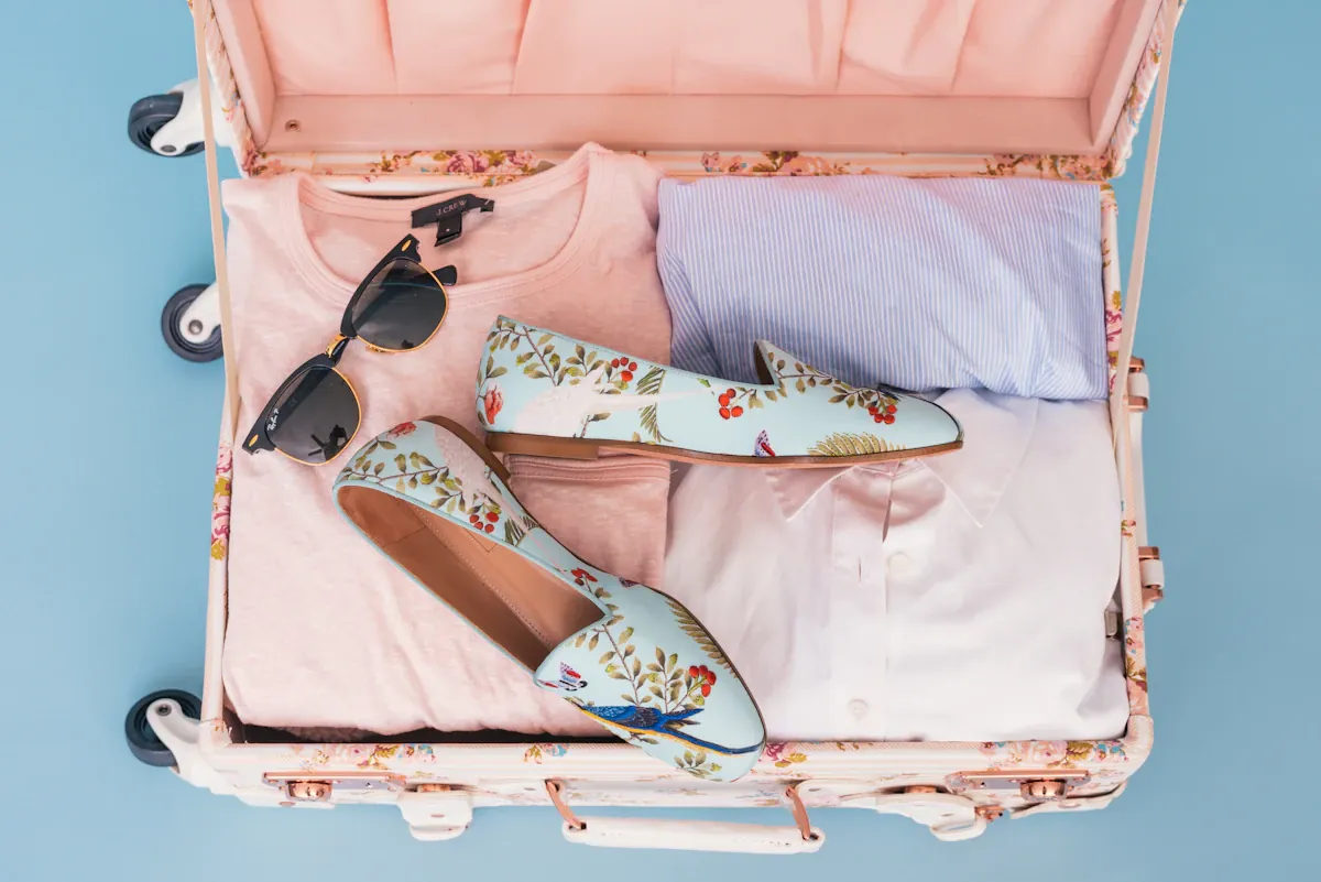 Clothing and a pair of shoes packed in luggage