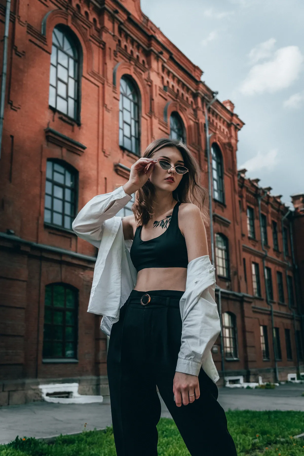 A woman wearing a white cardigan over a black top outdoors
